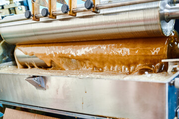Glue application machine operates expertly, ensuring efficient hot glue coverage for industrial...