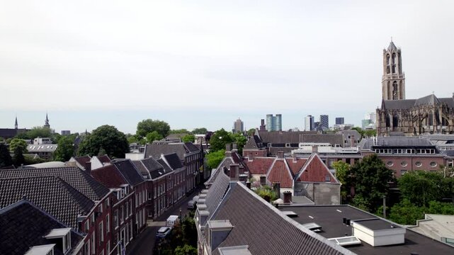 Ascending aerial reveal of historic city center Utrecht with De Dom cathedral tower and the gothic church architecture. Holland religious tourist destination seen from above.