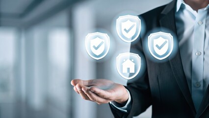 Businessperson presenting digital shields and home icons, symbolizing protection, insurance, and security in a modern, professional environment.