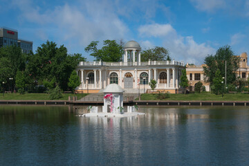 The Planetarium building on the shore of Swan Lake and the Swan House opposite on a sunny summer day, Astrakhan, Russia