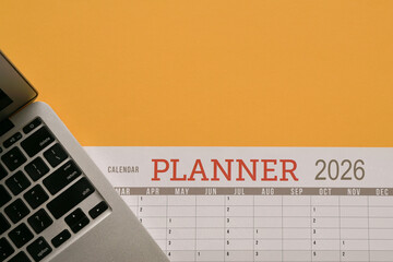 2026 Planner, next to computer laptop. Top view.