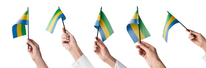 The Gabon flag in hand in different angles on a white background