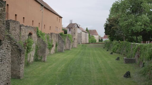 Medieval stone wall along grassy courtyard