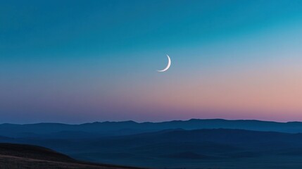 Fototapeta premium Crescent Moon Over Silhouetted Hills at Dusk