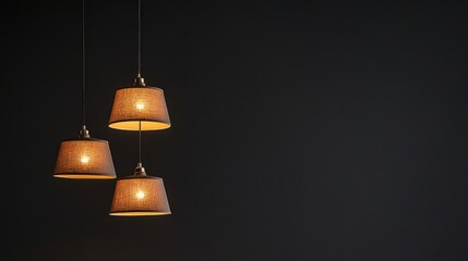 Obraz premium Three Hanging Light Fixtures with Textured Shades Against a Dark Wall