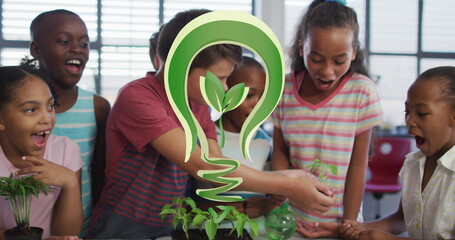 Image of bulb with plant over class of happy diverse pupils planting flowers at school