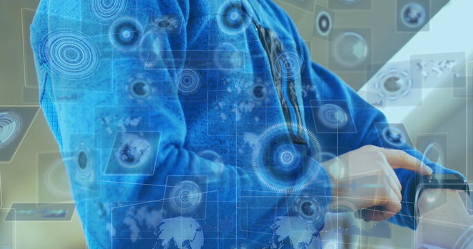 Pointing man in blue jacket checking smartwatch in modern office, with digital interface elements - Powered by Adobe