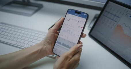 Female Financial Analyst Checking Real-Time Stocks, Exchange Market Charts on Smartphone and Tablet Computer Using Online Trading Mobile App. Businesswoman Working in Investment Bank Office. Close Up. - Powered by Adobe