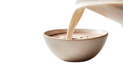 Pouring milk into a bowl of chocolate cereal, white isolate background.