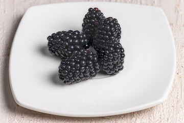 Minimalist Close-Up of Fresh Blackberries on White Plate