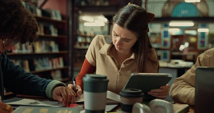 Group, studying and students in library, tablet and deadline for assignment, education and learning. Friends, university and people with technology, books and knowledge with scholarship and exam prep