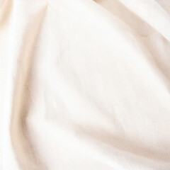 Neutral white cotton linen fabric background. Soft plain textile top view surface earth tone color. Close-up texture of natural white cloth for display products, mockups or presentations.