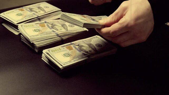 The man counts the money in piles. Concept of thrift, saving, making money