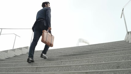 Top view of smart business man walking up stairs with bag in the hand. Professional project manager climb up the stair and going to workplace. Increasing skill, getting promotion, traveling. Exultant.