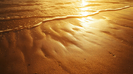 Golden sandy beach at sunset with long shadows and the peaceful sea in the distance