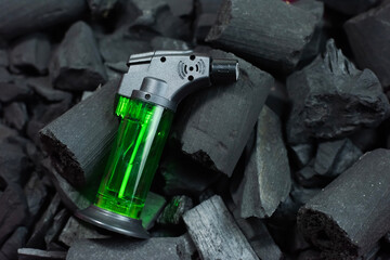 Green lighter on black charcoal