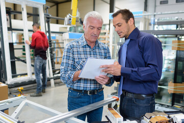 workers writting notes in window frame in workshop