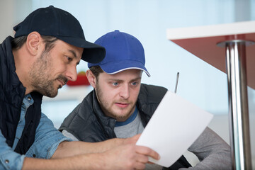 2 male workers checking some paperwork