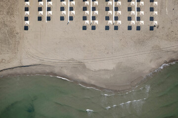 Perfect geometry of shadows and umbrellas on a deserted beach seen from above