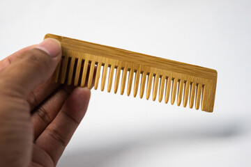 Hand hold Wooden comb isolated in white background. use eco-friendly products for sustainability
