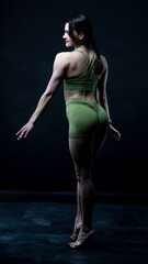 Obraz premium Young beautiful woman with athletic body on dark background. Fitness girl 