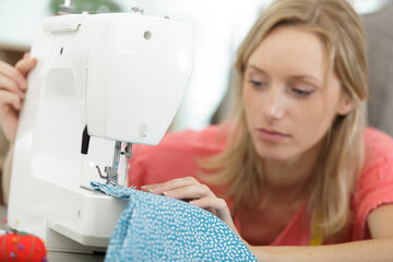 woman sewing fabric with sewing equipments