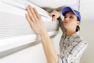 handywoman cleaning fixing ventilation system