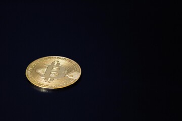 Golden Bitcoin isolated on black background. Symbol of cryptocurrency, blockchain technology, and digital financial innovation. 