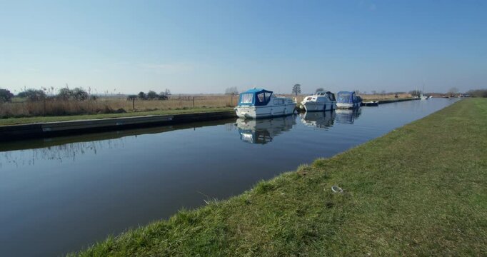 Long shot looking down a inlet on the river Thurne at the village of Thurne
