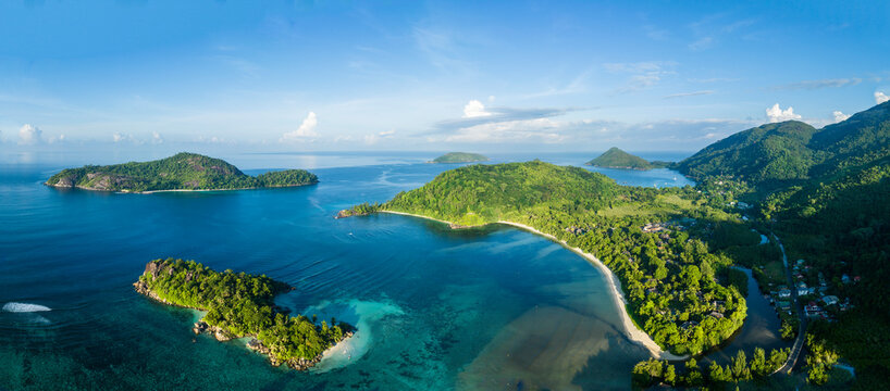 Aerial view of Port Launay Beach in Mahe, Seychelles, with lush greenery and clear blue waters.
