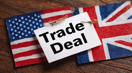 US and UK flags display trade deal agreement on wooden table
