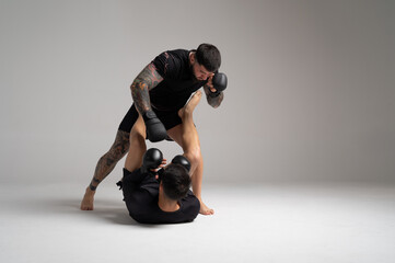 Two mma fighters sparring on gray background