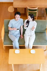 Fotobehang リビングのソファでくつろぐ夫婦 © ponta1414