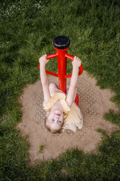 Little girl playing on a spinner outdoor playground