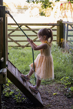 Little girl at outdoor playground climbing wall