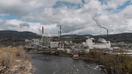 Obraz premium Large factory with pollution in Maine along the banks of a river
