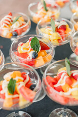 Fruit salad cups with yogurt drizzle and mint garnish