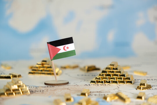 Small Sahrawi Republic flag stands with gold bars on a world map, symbolizing national resource wealth, economic strategy, and global financial influence