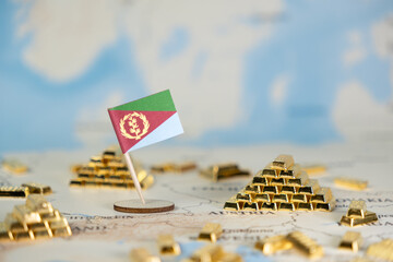 Naklejka premium Eritrean flag on global world map featuring gold bars, symbolizing national economic wealth, valuable mineral resources, and international financial investment, offering copy space
