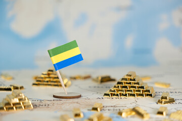 Gabon flag on a world map with gold bars, symbolizing global finance, national wealth, resource management, and economic strategy with ample copy space