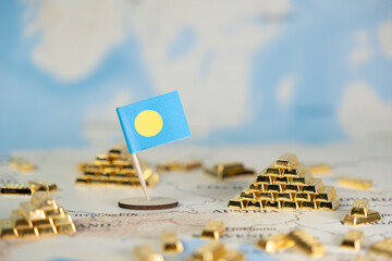 Palau flag proudly standing amidst shining gold bars on a world map, symbolizing national economic...