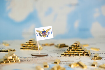 A national flag of the U.S. Virgin Islands stands on a world map surrounded by gold bars, representing global wealth, investment, and economic strategy © Alina