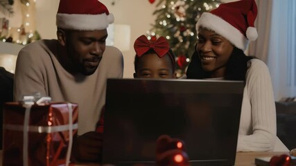 An African American family, wearing Santa hats, shares a joyful moment during the holidays. They are gathered around a laptop, their faces filled with laughter. A Christmas tree shines softly in the - Powered by Adobe
