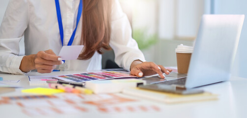 Creative Collaboration in Design. Professionals analyzing color palettes and layouts during a...