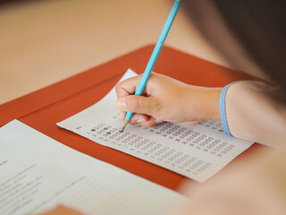 Closeup of hands female of students taking exams in a classroom, exams in school, writing and...