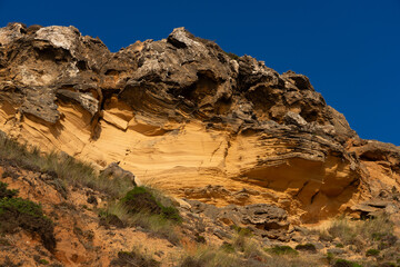Telheiro beach at sunset in Sagres, Portugal, with its colorful cliffs.