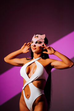Fototapeta Female dancer in pink cat mask showcases moves in vibrant studio setting