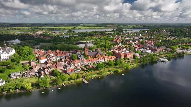 Aerial footage of historic townscape of Pl&ouml;n by the lake Pl&ouml;ner See, Schleswig-Holstein, Germany. Pl&ouml;n and its lake landscape. Aerial orbit of St Nicholas' church in historic town Pl&ouml;n.