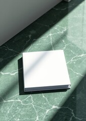 Square book mockup on green marble surface with sunlight. book mockup. 
