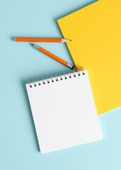 Spiral notepad with pencil as mockup for your design. note book on pastel blue background. book mockup. 